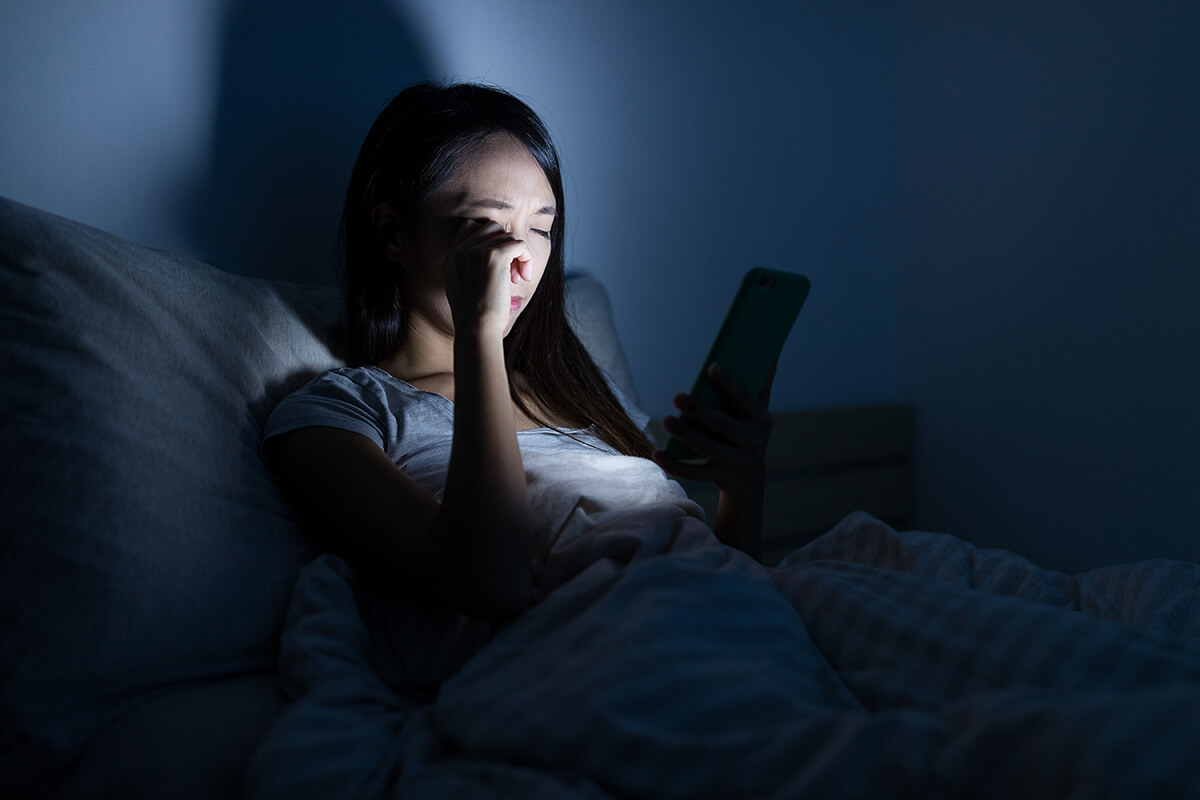 woman suffering from insomnia on her mobile device